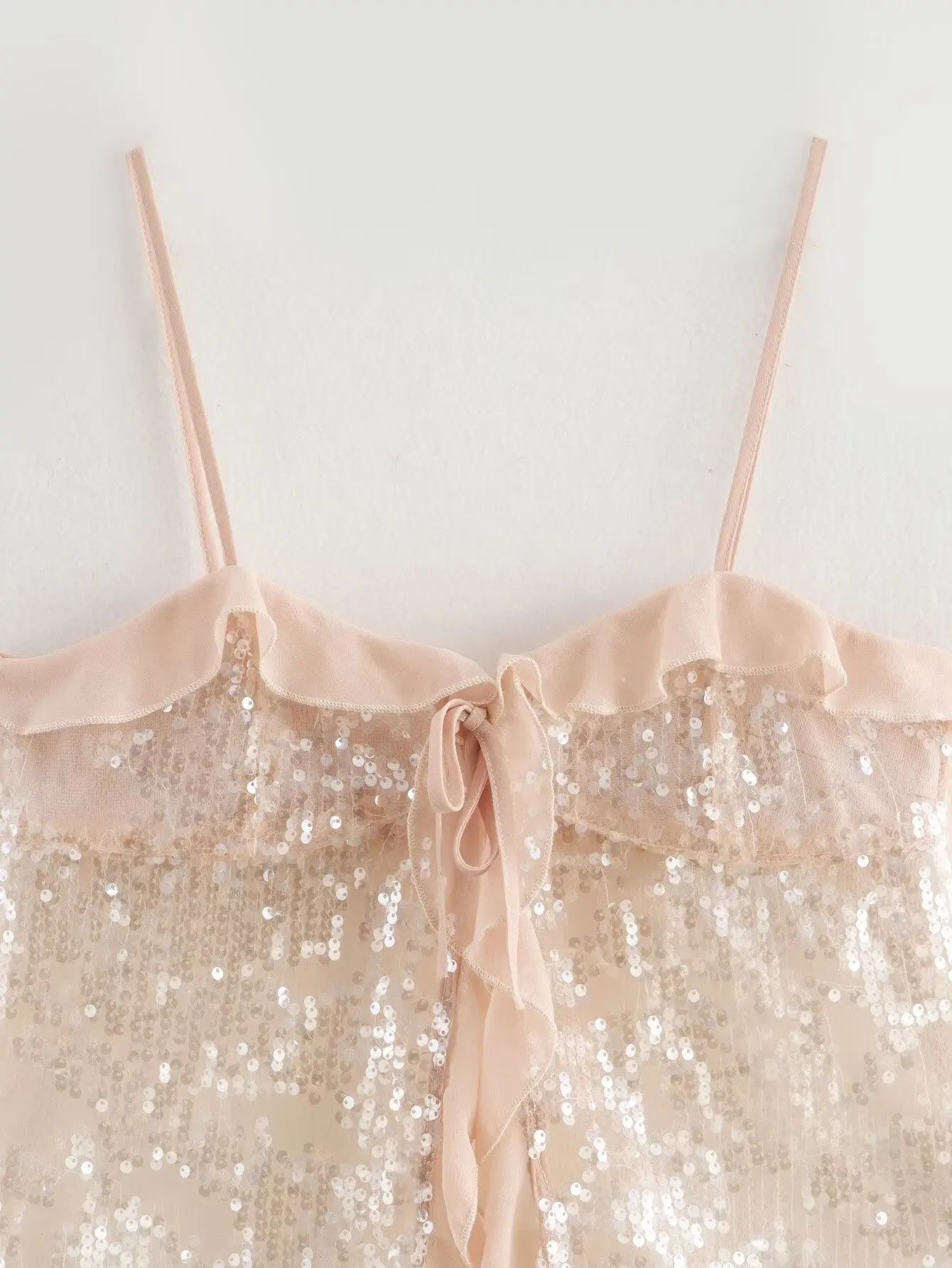 Sparkle & Satin Sequin Cami Top – Blush Nude.  Elevate your evening style with this dazzling sequin cami top in a dreamy blush nude tone. Designed with a soft satin ruffle neckline and delicate spaghetti straps