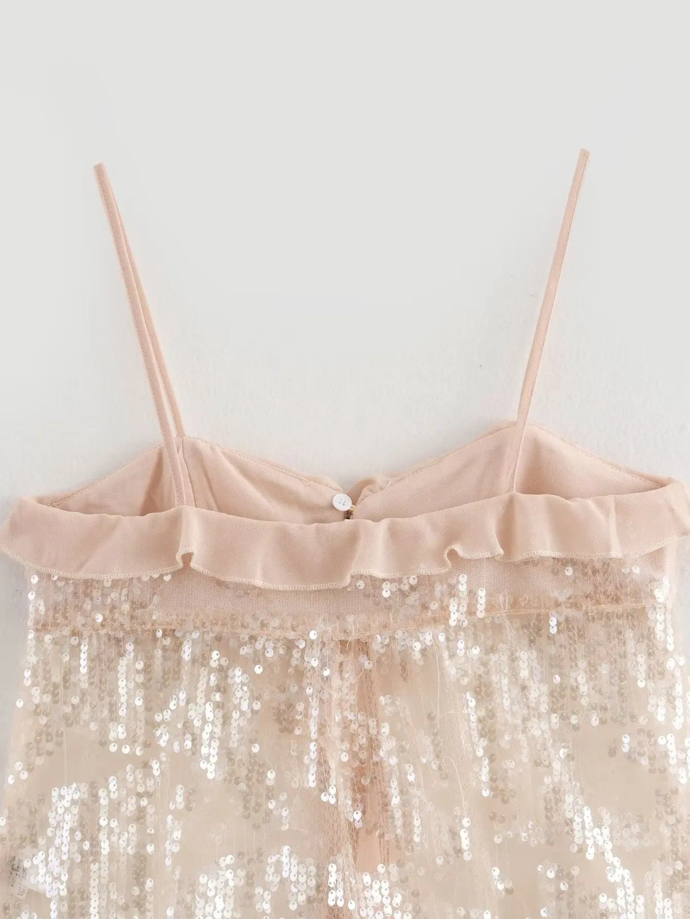 Sparkle & Satin Sequin Cami Top – Blush Nude.  Elevate your evening style with this dazzling sequin cami top in a dreamy blush nude tone. Designed with a soft satin ruffle neckline and delicate spaghetti straps