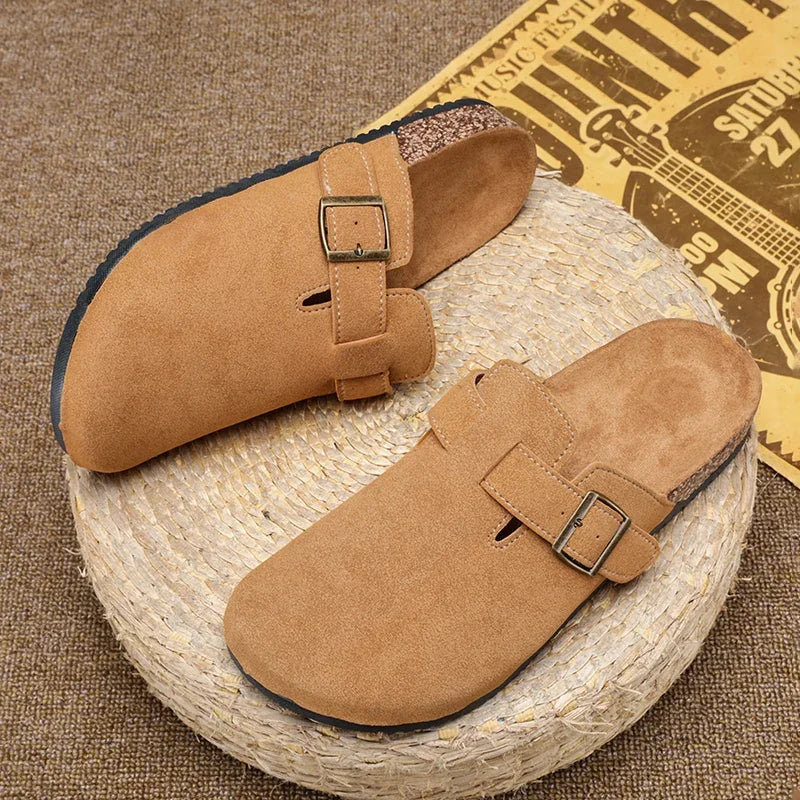 Casual slip-on clogs. Featuring a soft suede-like upper, contoured cork footbed, and an adjustable buckle strap