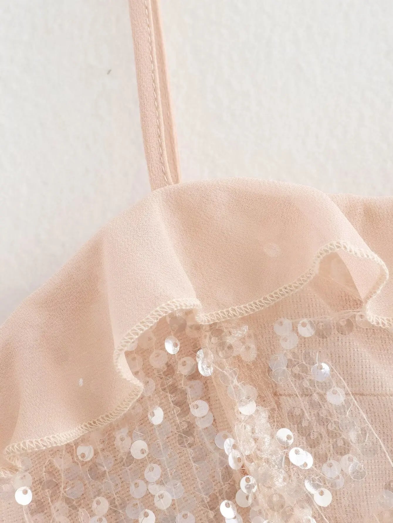 Sparkle & Satin Sequin Cami Top – Blush Nude.  Elevate your evening style with this dazzling sequin cami top in a dreamy blush nude tone. Designed with a soft satin ruffle neckline and delicate spaghetti straps